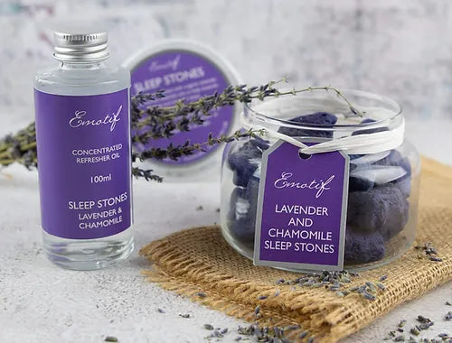 Lavender & Chamomile Aromatherapy Sleep Stones, sleep stone jar open and on folded beige fabric with bottle of sleep oil and dried lavender