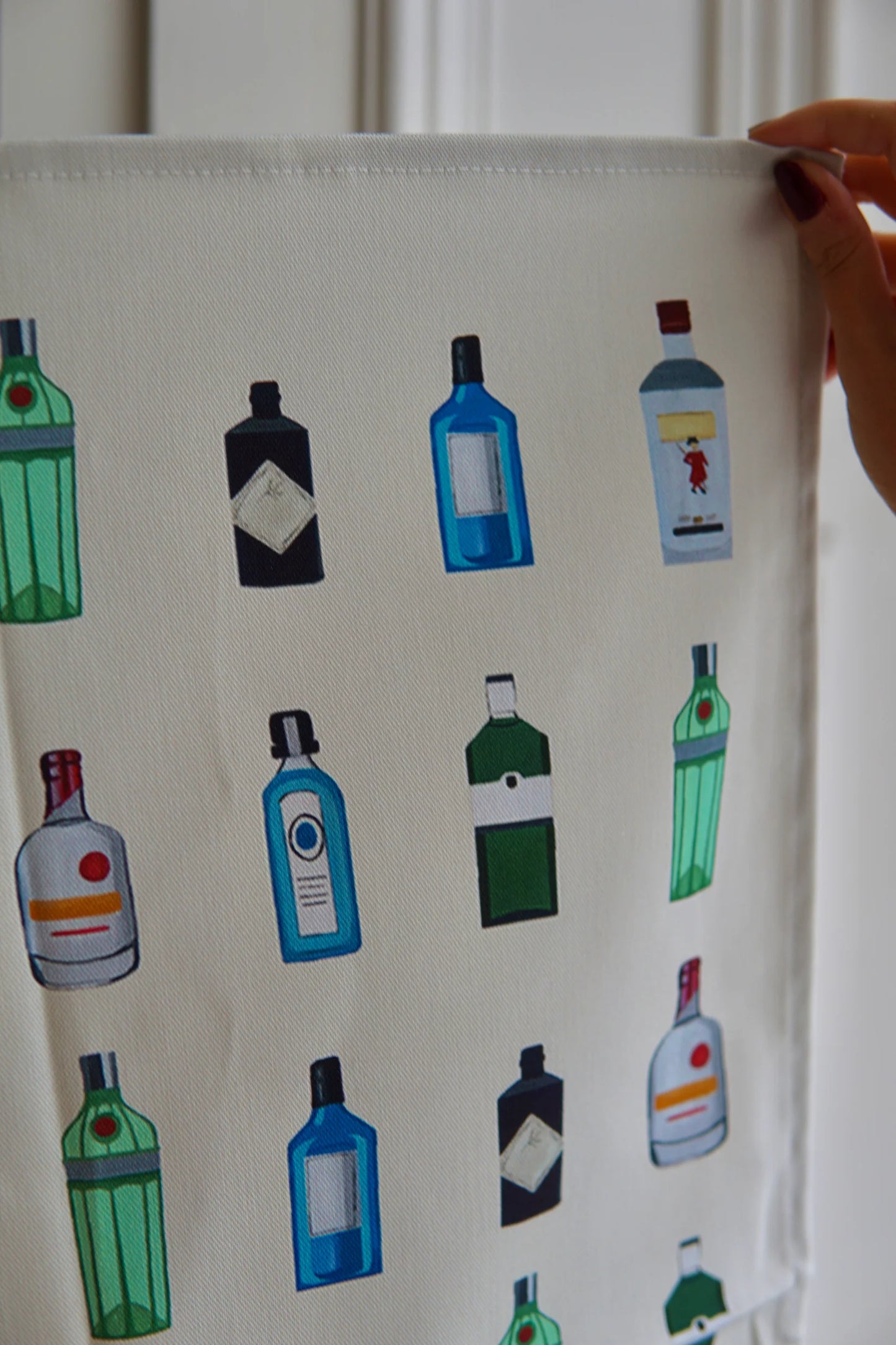 White Gin Tea Towel being held by woman's hand.  