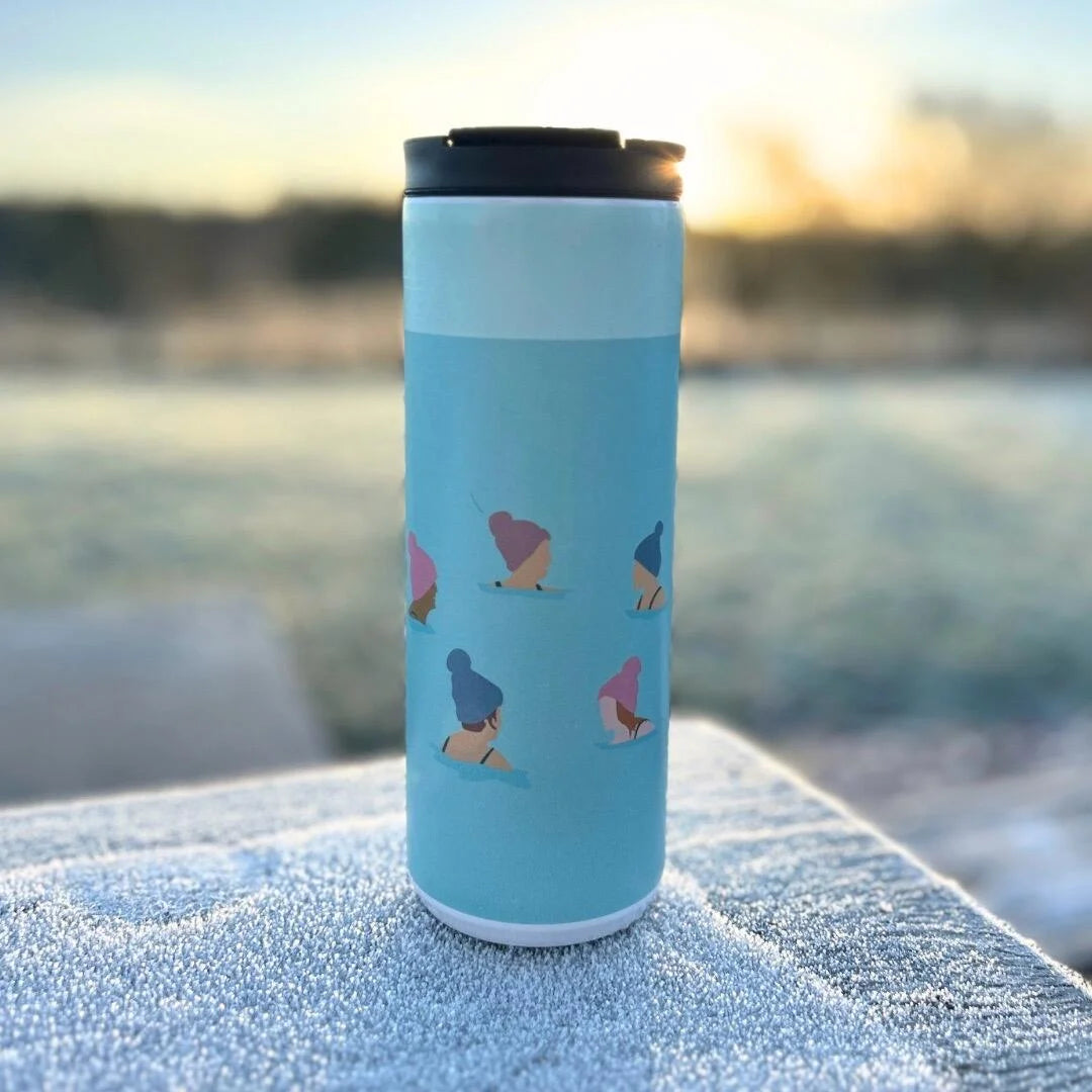 Wild Swimming Thermal Cup on frosty surface with blurred grass and trees behind.  